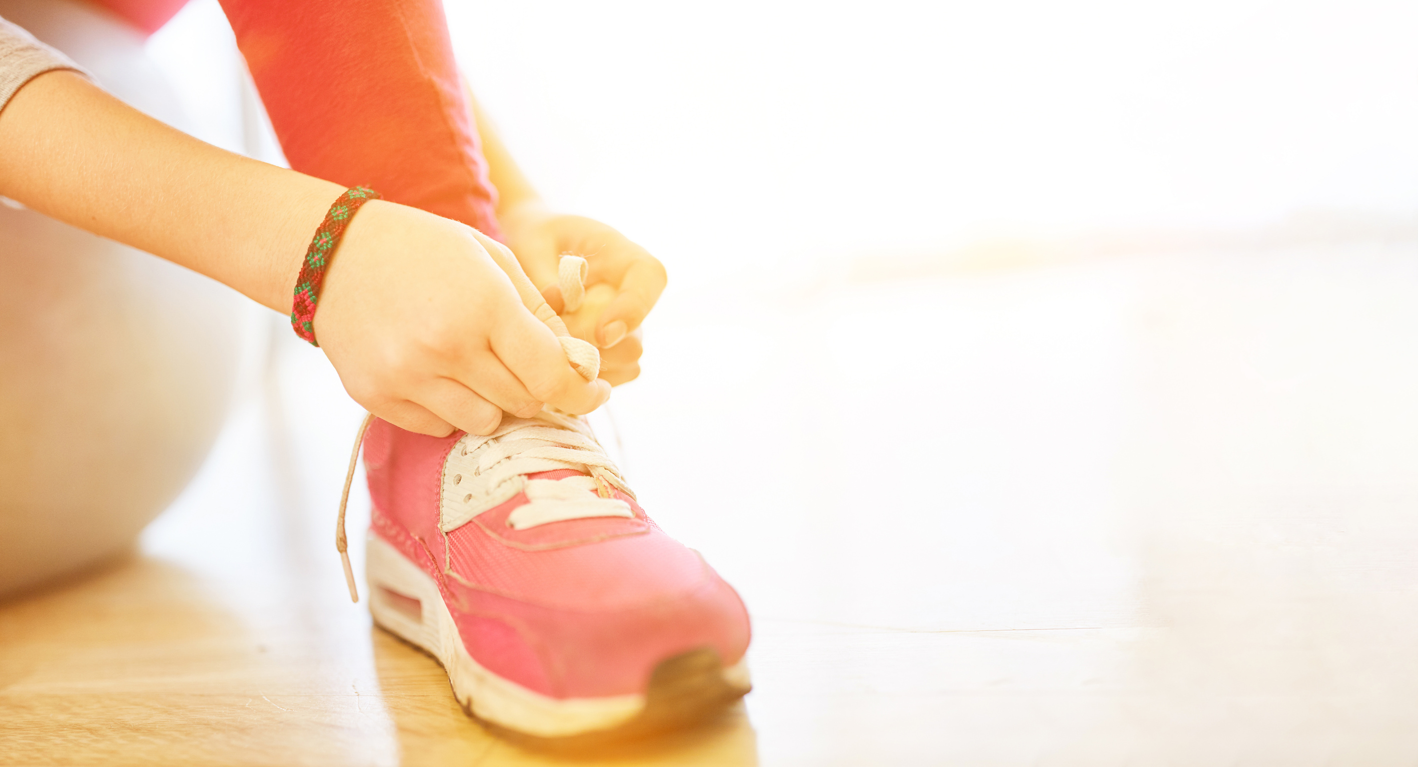 A child is learning to tie shoes